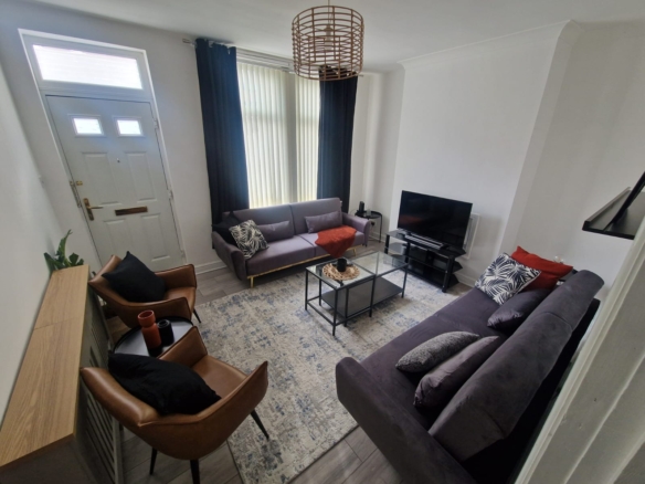 TV lounge with a sofa set and leather chairs by hmh stays
