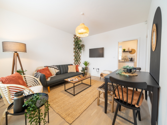 TV lounge with sofa set in the property of HMH Stays in Uk