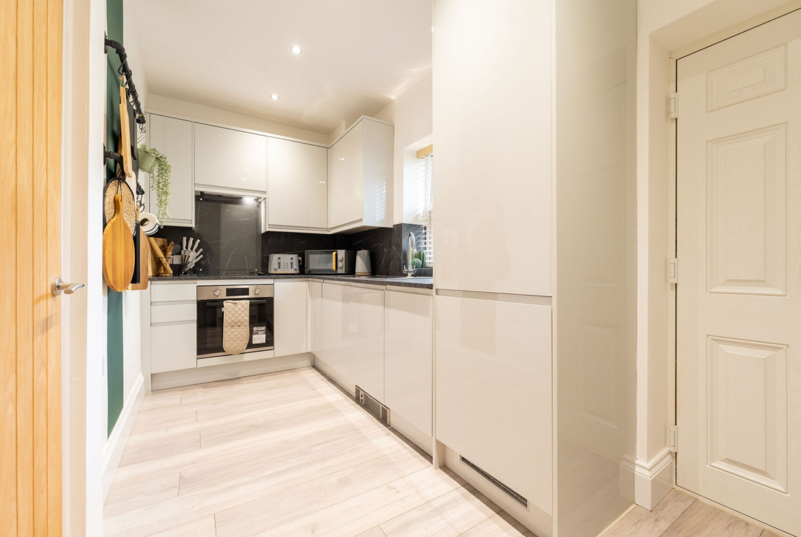 Kitchen having sandwich maker, microwave, knives and sink to help in cooking for contractors listed by hmh stays providing long-term accommodation