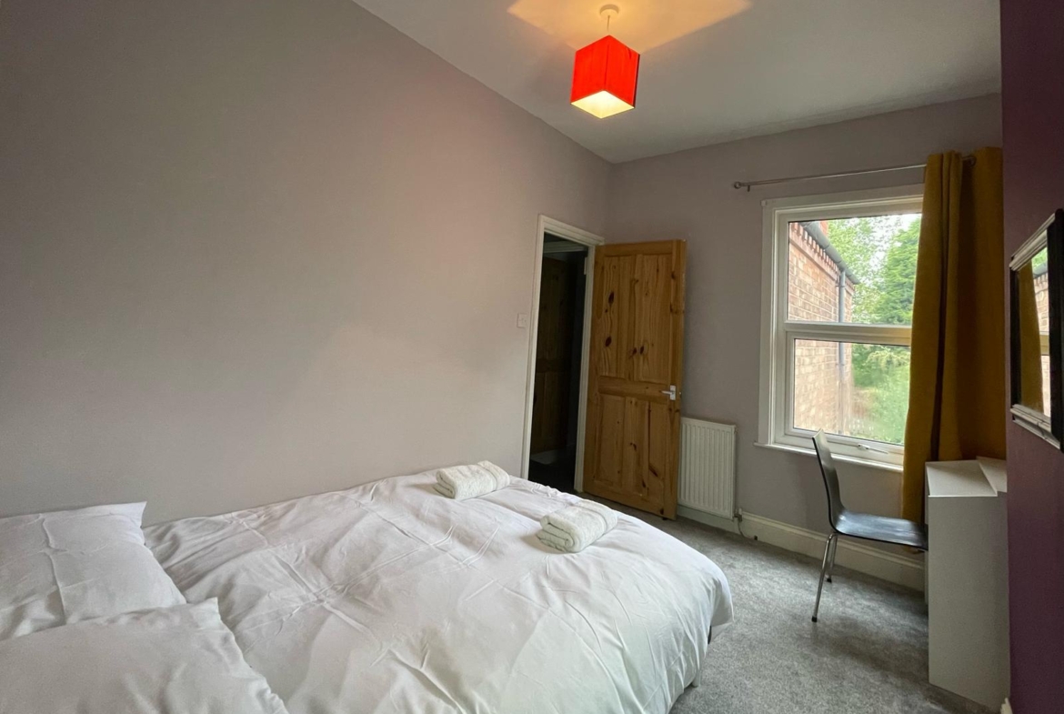 Double bed with the white sheet in the property of hmh stays